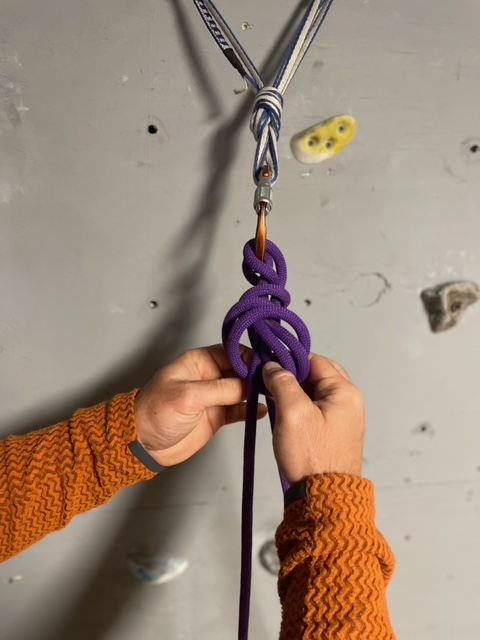 tying off munter mule knot with overhand knot
